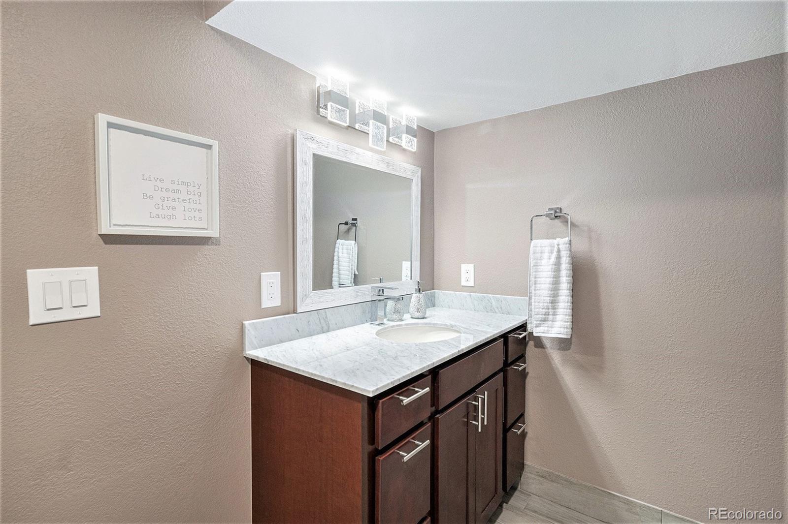 904 Fieldstone Place Highlands Ranch, CO 80126 - Photo 17 of 28 a bathroom with a granite countertop sink and a mirror