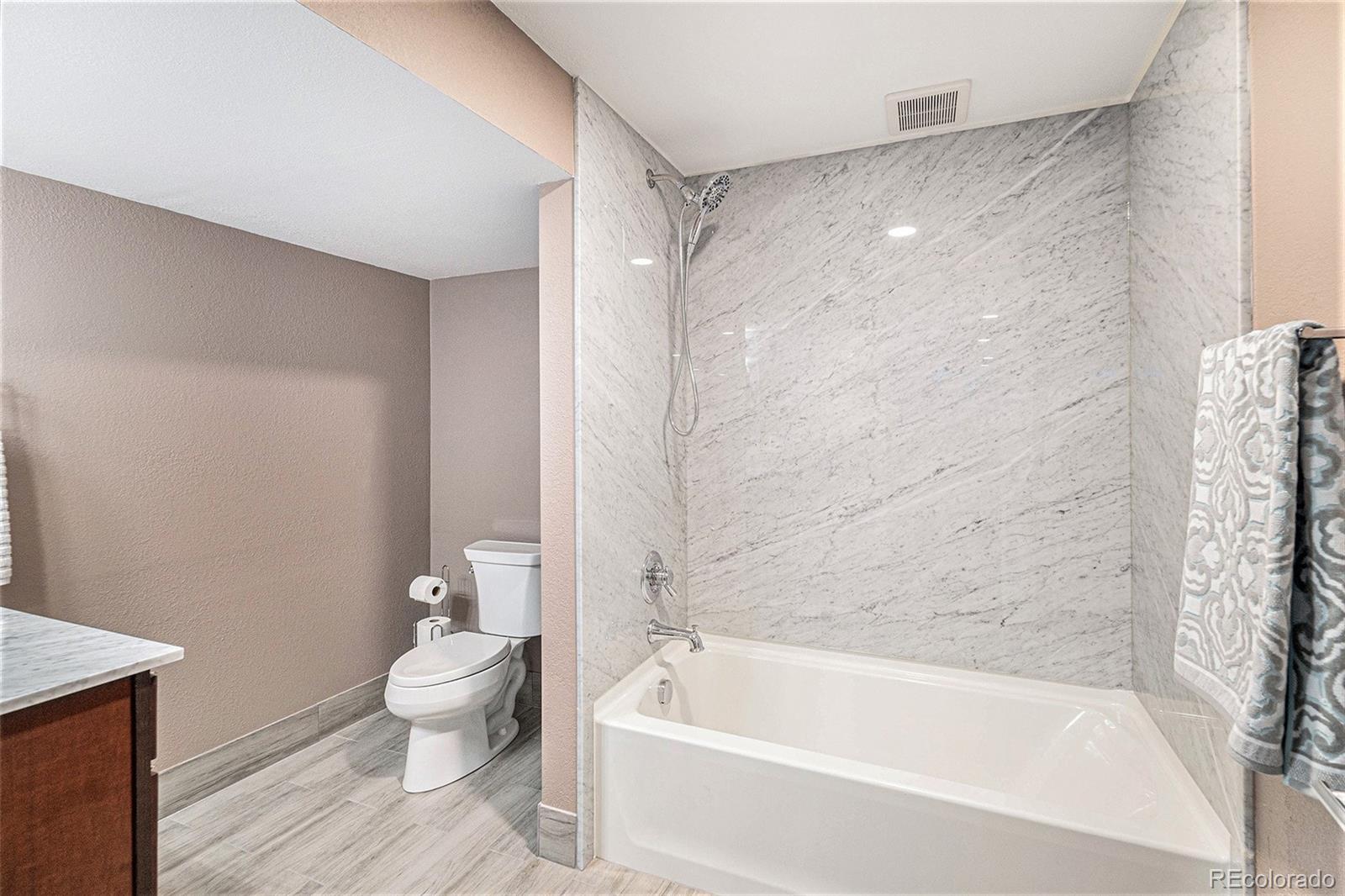 904 Fieldstone Place Highlands Ranch, CO 80126 - Photo 18 of 28 a bathroom with a bathtub shower and toilet