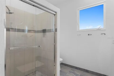 a spacious bedroom with a large bed and a large window