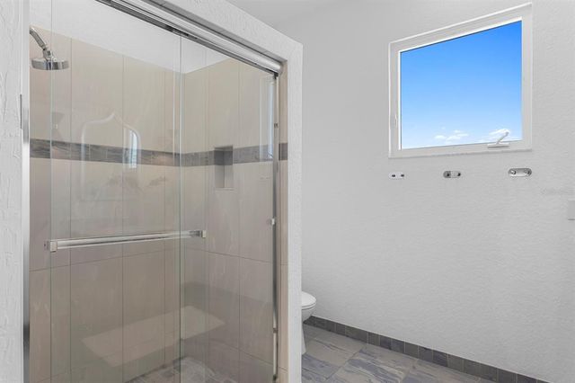 a spacious bedroom with a large bed and a large window