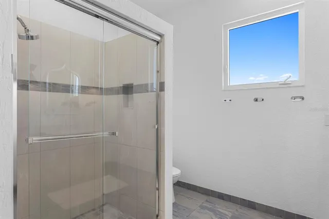 a spacious bedroom with a large bed and a large window