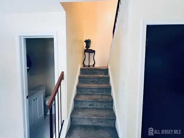 a view of a hallway with wooden floor and stairs