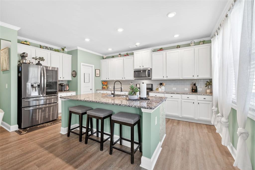 4479 Big Rock Rdg Trail Gainesville, GA 30504 - Photo 12 of 45 a kitchen with stainless steel appliances granite countertop a refrigerator a sink dishwasher a stove and white cabinets with wooden floor