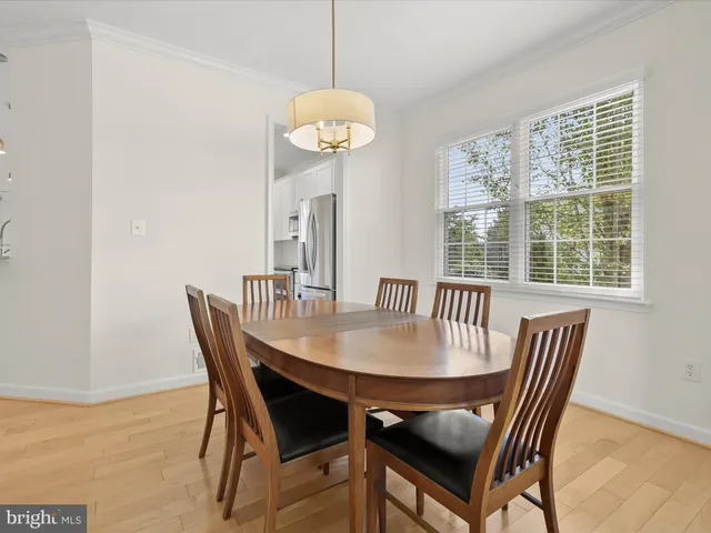 a kitchen with granite countertop a sink a stove a dining table and chairs