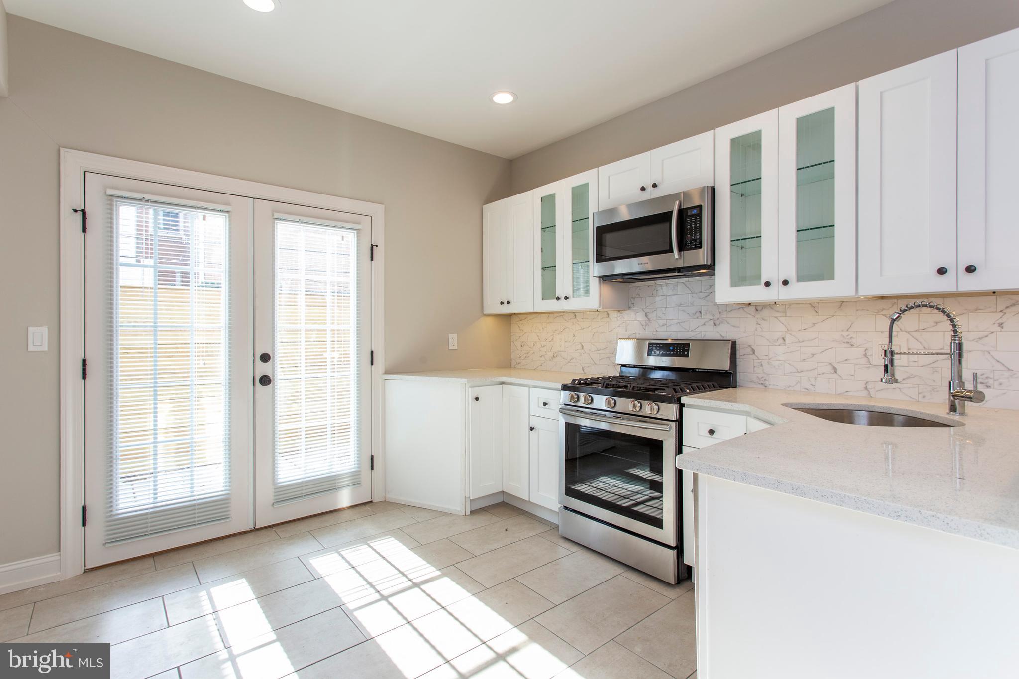 2052 Gerritt Street Philadelphia, PA 19146 - Photo 8 of 32 a kitchen with stainless steel appliances granite countertop a stove a sink and a microwave