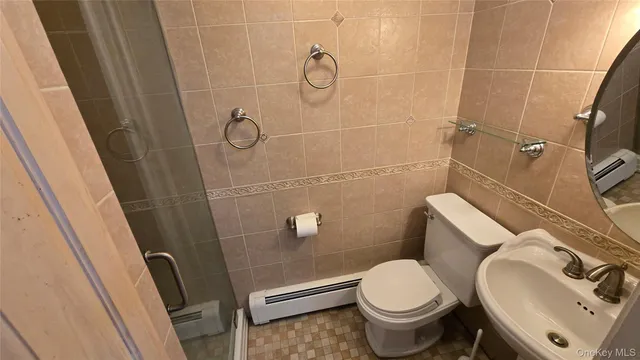 a bathroom with a granite countertop sink toilet a mirror and shower