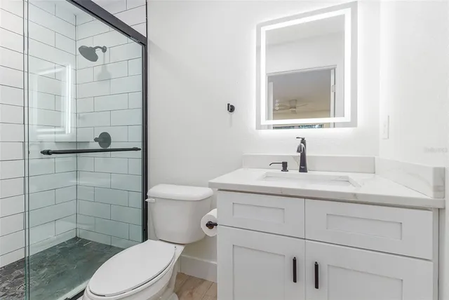 a bathroom with a sink a toilet and shower