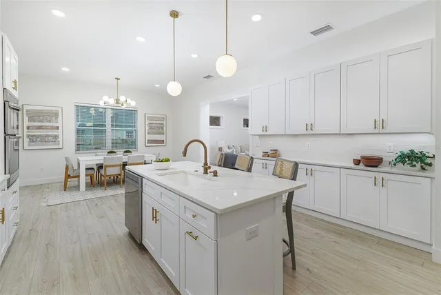 a kitchen with a stove a sink a center island and cabinets