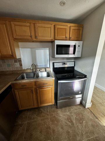 2800 Northwest 56th Avenue, Unit D304 Lauderhill, FL 33313 - Photo 1 of 13 a kitchen with granite countertop a sink a stove and cabinets