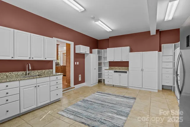 a kitchen with stainless steel appliances kitchen island granite countertop a refrigerator and a stove top oven