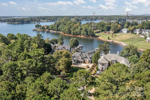 an aerial view of a house with a yard and lake view