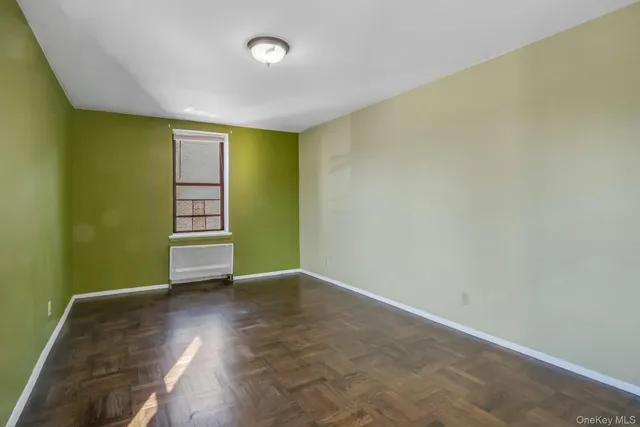 an empty room with wooden floor and white walls