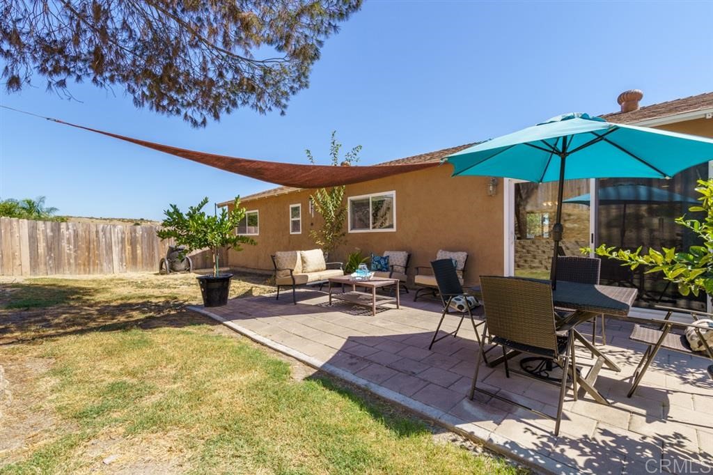 9456 Cathywood Drive Santee, CA 92071 - Photo 20 of 25 a patio with a table and chairs under an umbrella