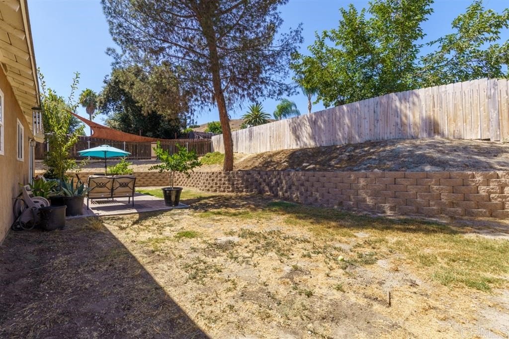 9456 Cathywood Drive Santee, CA 92071 - Photo 21 of 25 a view of a backyard with large trees and wooden fence