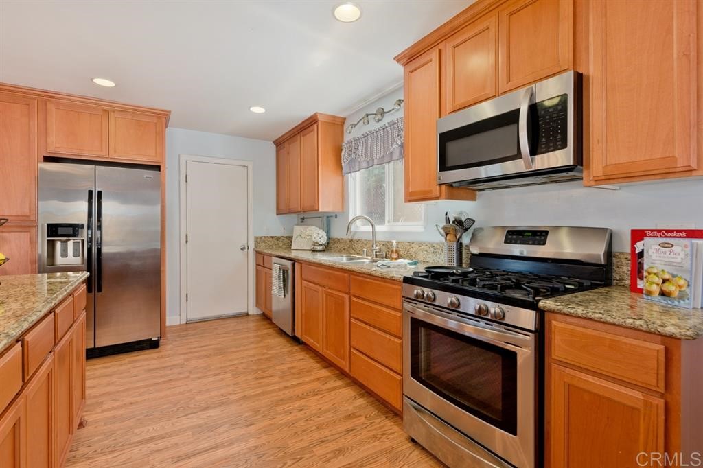 9456 Cathywood Drive Santee, CA 92071 - Photo 9 of 25 a kitchen with stainless steel appliances granite countertop a stove a sink and a microwave