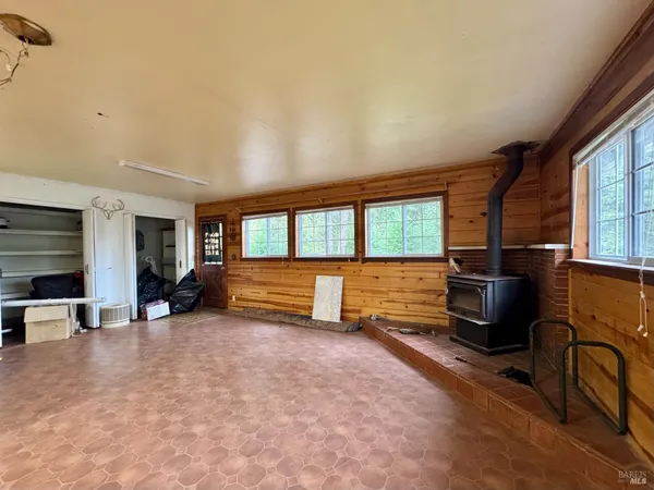 an empty room with a ceiling fan and windows