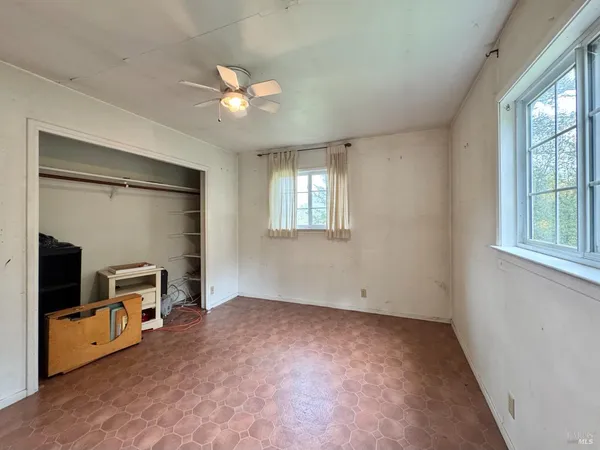 a view of an empty room with a chandelier fan
