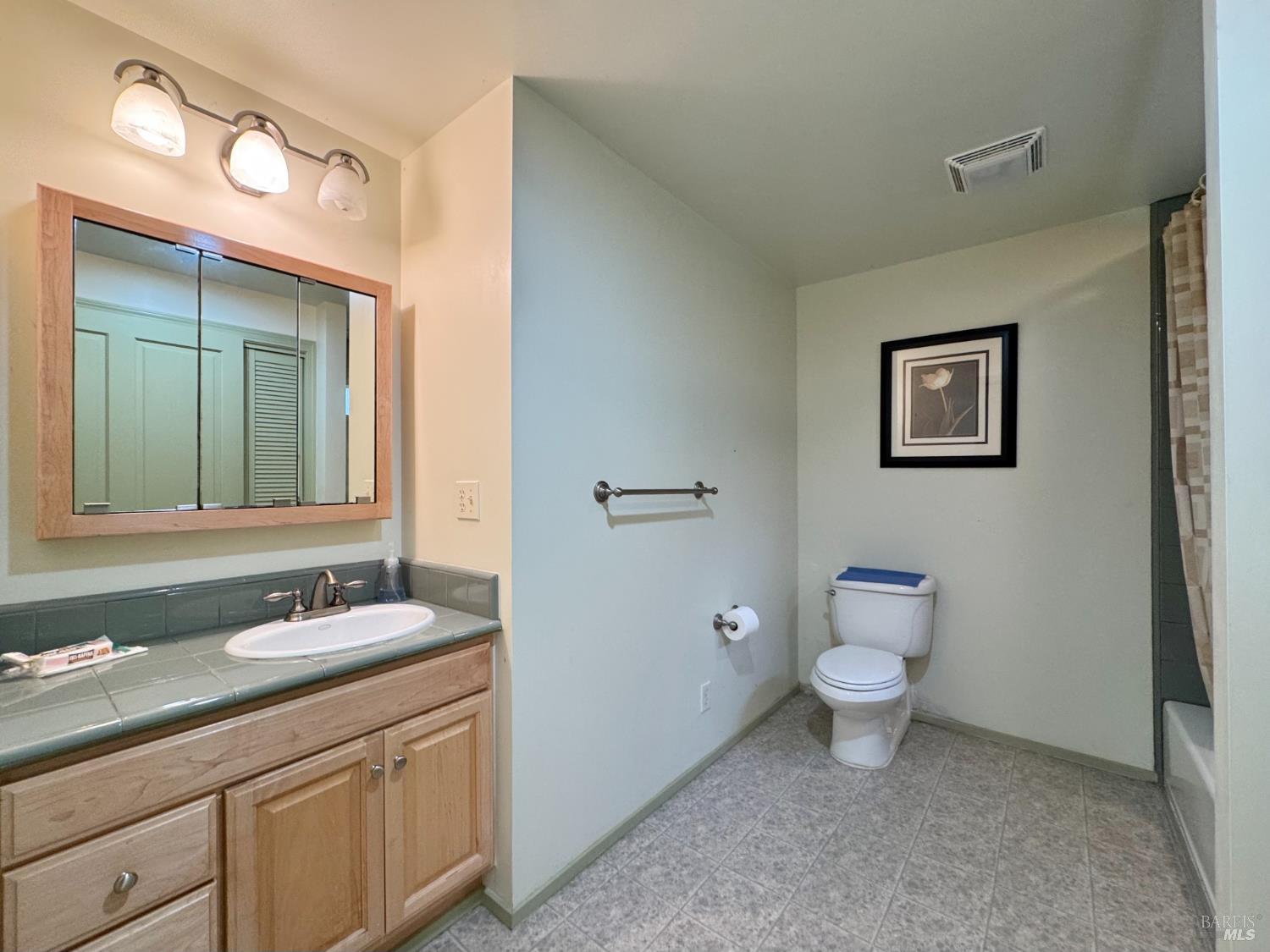 5083 Dry Creek Road Napa, CA 94558 - Photo 60 of 90 a bathroom with a granite countertop sink toilet and mirror