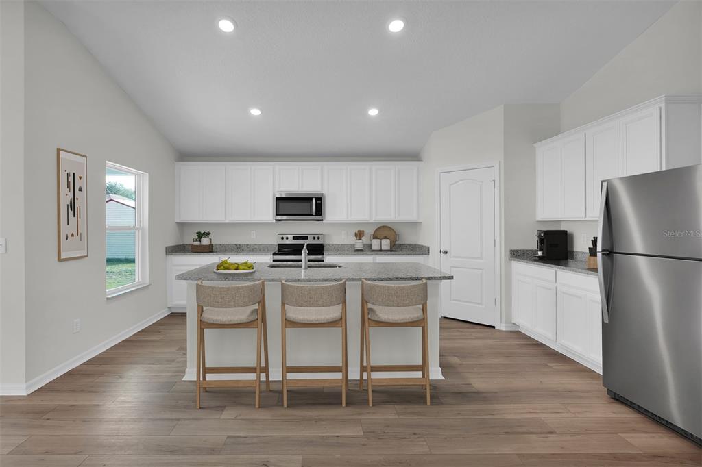 2 Prince Eric Lane Palm Coast, FL 32164 - Photo 4 of 20 a kitchen with stainless steel appliances a refrigerator a stove a sink dishwasher and white cabinets with wooden floor