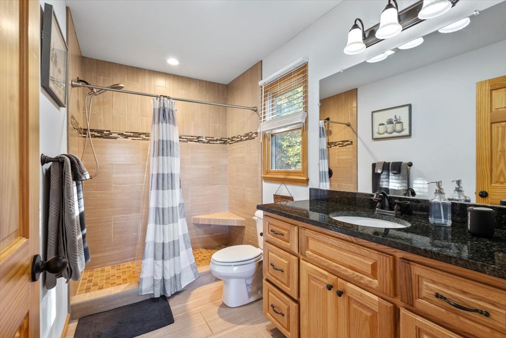 190 Regency Drive Murphy, NC 28906 - Photo 33 of 42 a bathroom with a granite countertop sink a toilet a mirror and shower