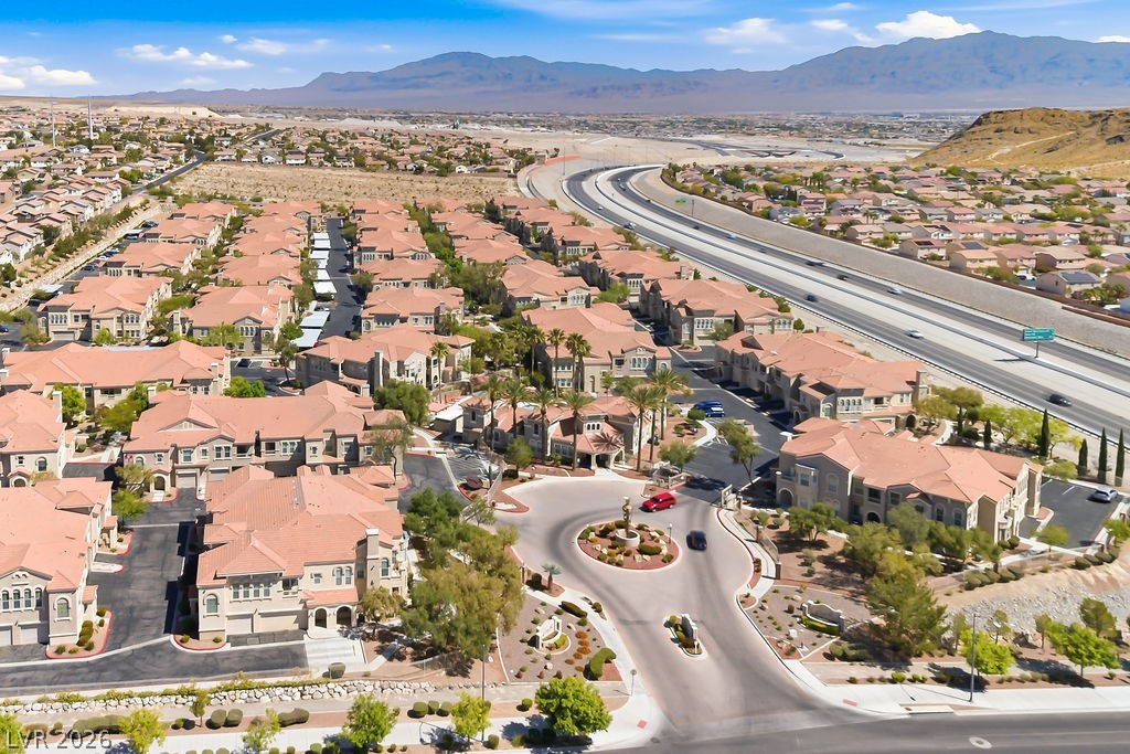 10550 West Alexander Road, Unit 2133 Las Vegas, NV 89129 - Photo 20 of 42 An aerial view showcases a vibrant community with terracotta rooftops, nestled near a bustling highway.