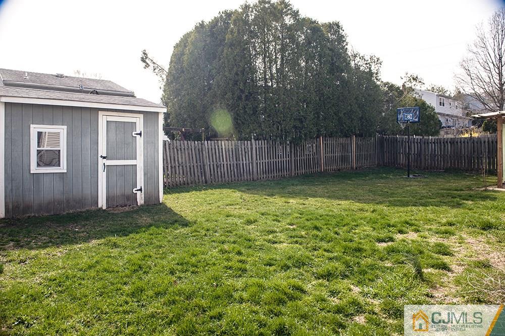 56 Brookside Road Edison, NJ 08817 - Photo 3 of 24 a view of a backyard with a small cabin and wooden fence