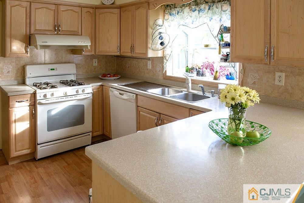 56 Brookside Road Edison, NJ 08817 - Photo 4 of 24 a kitchen with stainless steel appliances granite countertop a sink a stove and a wooden floors