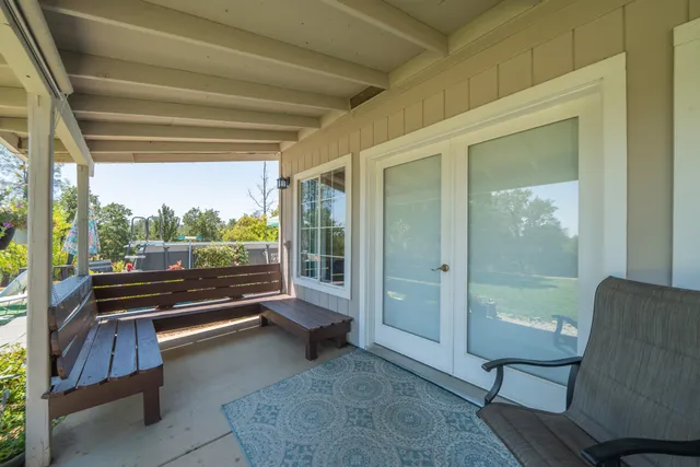 a view of a porch with a floor to ceiling window next to a yard