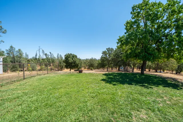 an aerial view of a house with a yard and trees