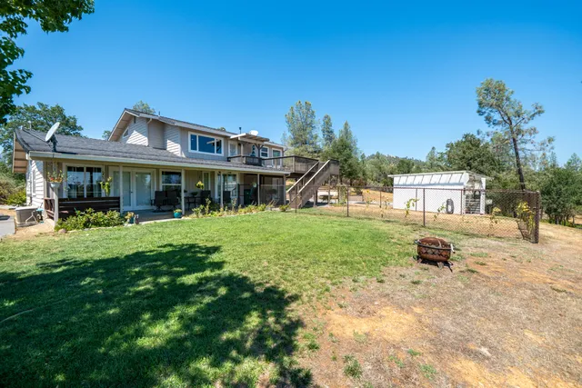 a view of a house with backyard and sitting area