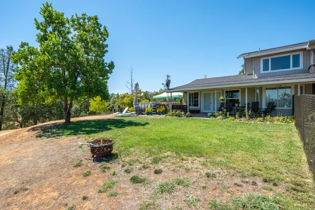a front view of house with yard and trees in the background