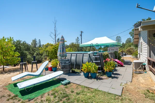 a backyard of a house with barbeque oven table and chairs
