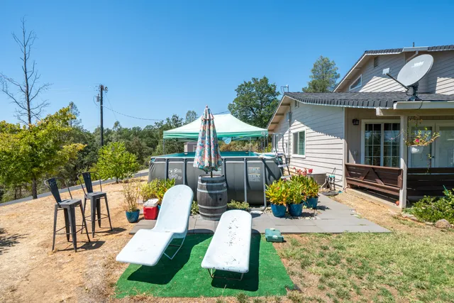 an aerial view of a house with a yard and a wooden deck