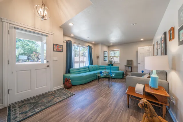 a kitchen with stainless steel appliances granite countertop a refrigerator a sink dishwasher a stove and a dining table with wooden floor