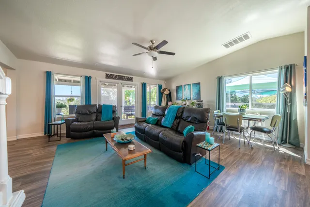 a dining room with furniture a floor to ceiling window and wooden floor
