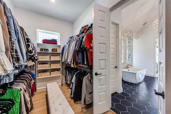 a view of walk in closet with clothes and shoes