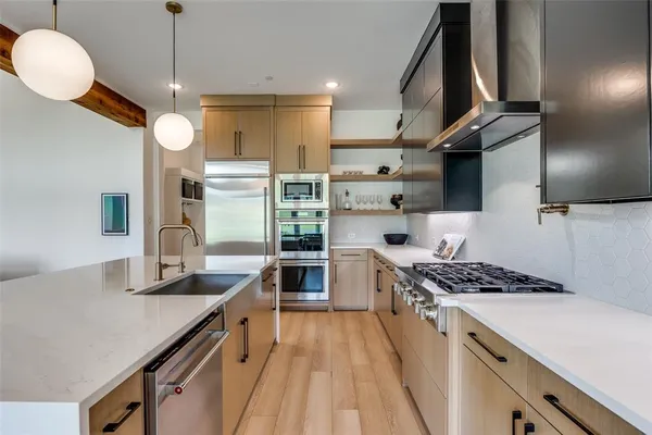 a kitchen with stainless steel appliances granite countertop a sink stove and refrigerator