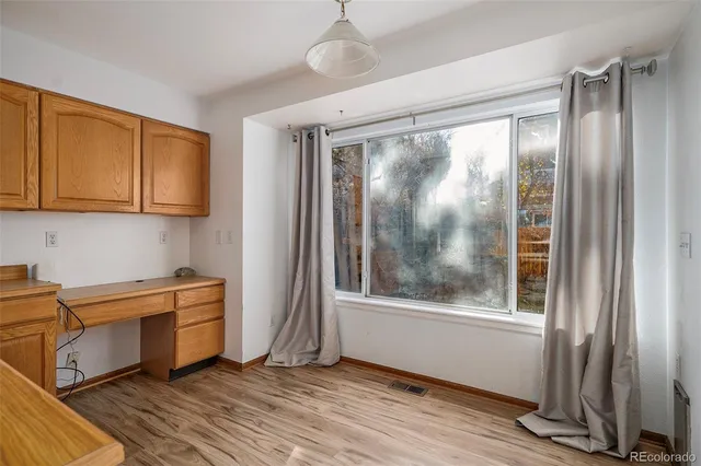 a view of a kitchen with wooden floor and a window