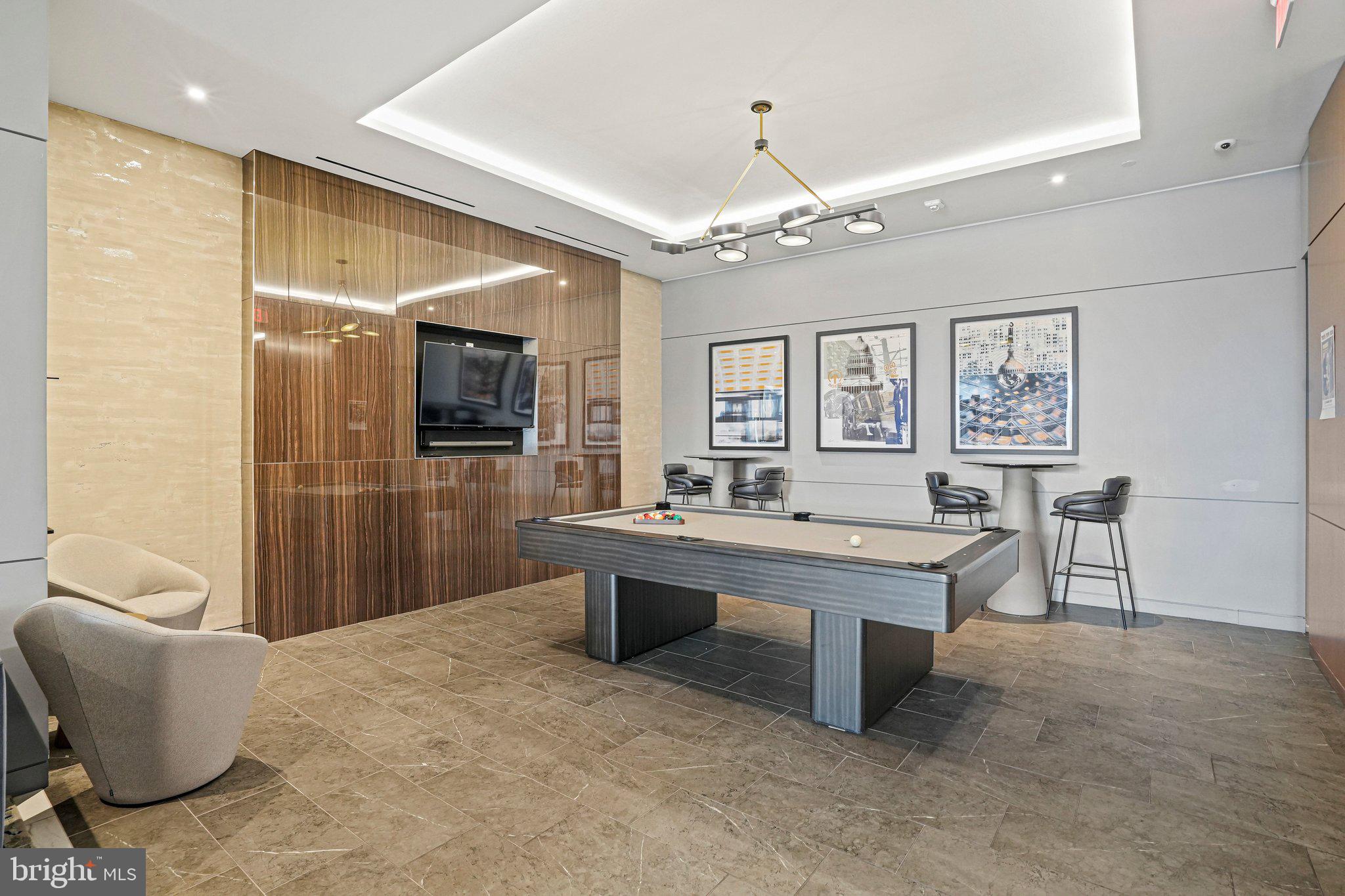 1211 Van Street Southeast, Unit 614 Washington, DC 20003 - Photo 13 of 21 a living room with furniture a chandelier and a flat screen tv