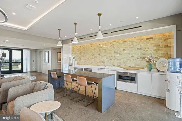 a living room with stainless steel appliances kitchen island granite countertop furniture and a large window
