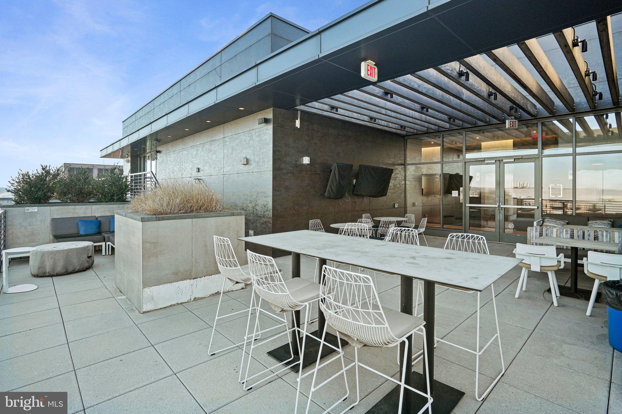 1211 Van Street Southeast, Unit 614 Washington, DC 20003 - Photo 10 of 21 a view of a patio with table and chairs potted plants and floor to ceiling window