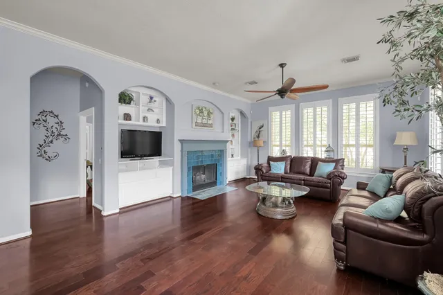 a kitchen with stainless steel appliances granite countertop a refrigerator a sink dishwasher a stove and white cabinets with wooden floor