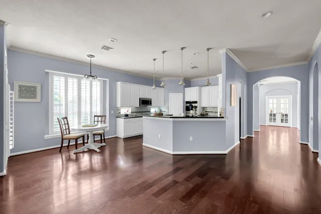 a kitchen with kitchen island a dining table and chairs