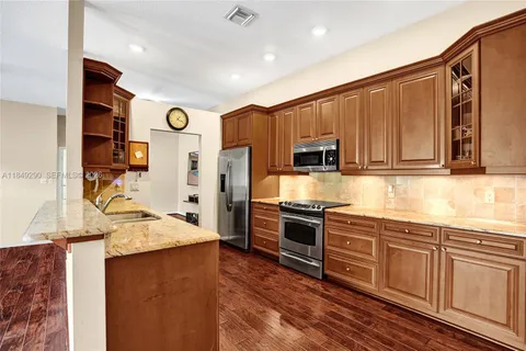 a kitchen with stainless steel appliances granite countertop a refrigerator stove and sink