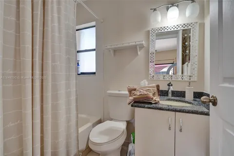 a bathroom with a granite countertop sink toilet a mirror and a shower