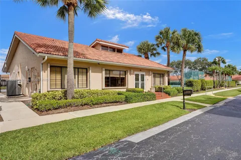 a front view of a house with a yard and potted plants