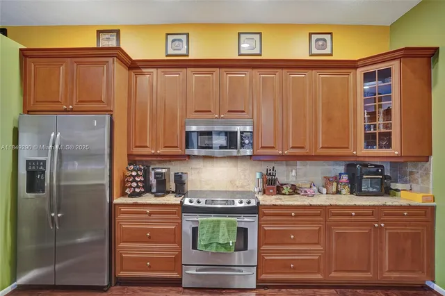 a kitchen with stainless steel appliances granite countertop a refrigerator and cabinets