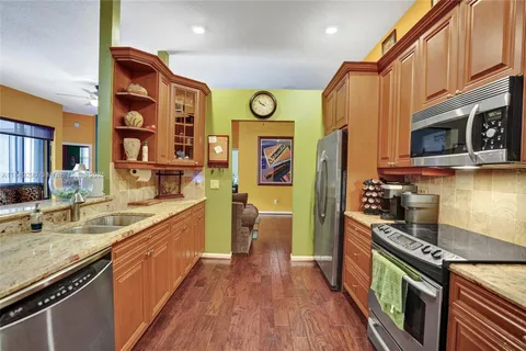 a kitchen with stainless steel appliances granite countertop a stove a sink and a refrigerator