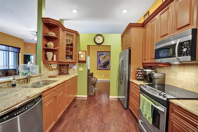 a kitchen with stainless steel appliances granite countertop a stove a sink and a refrigerator