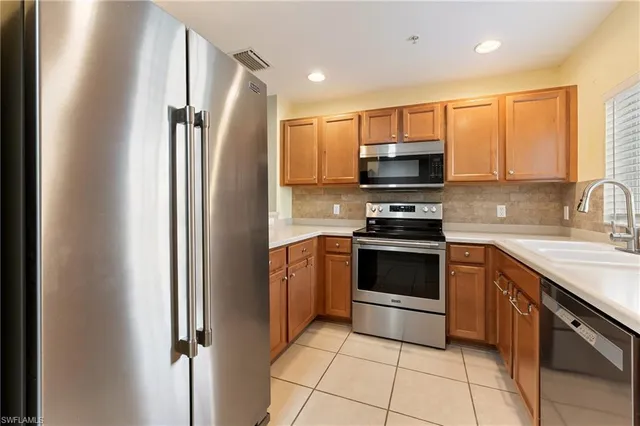 a kitchen with stainless steel appliances granite countertop a refrigerator and a sink